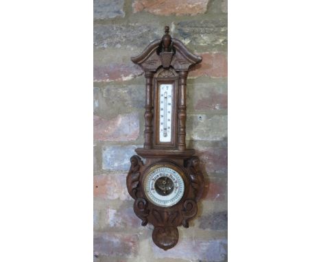 A carved oak barometer with thermometer, 57cm tall 