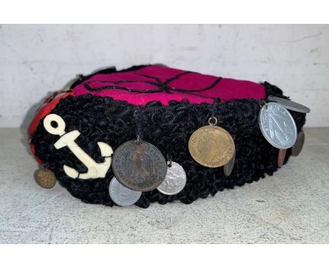 A WWII period astrakhan hat with red felt centre, attached coins, recovered in Belgium 1945 