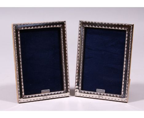 A PAIR OF SILVER AND ENAMEL BEAD EDGE PHOTOGRAPH FRAME. 7ins x 4.5ins.