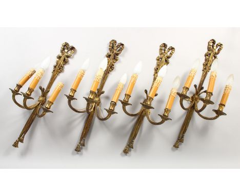 A SET OF FOUR CLASSICAL STYLE ORMOLU RIBBON AND BOW THREE LIGHT WALL APPLIQUES. 2ft 0ins high.