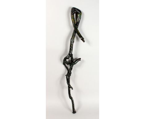 A FOLK ART WALKING STICK, carved as entwined snakes. 37ins long.