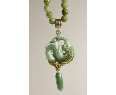 A GREEN JADE NECKLACE AND PENDANT.