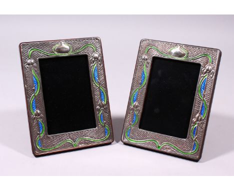 A PAIR OF SILVER AND ENAMEL ART NOUVEAU DESIGN UPRIGHT PHOTOGRAPH FRAMES. 7.5ins x 5.5ins.