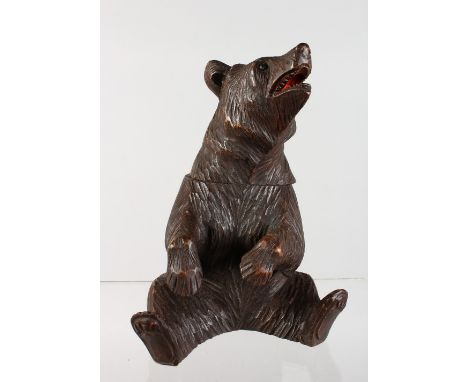 A BLACK FOREST CARVED WOOD SEATED BEAR CADDY. 8ins high.