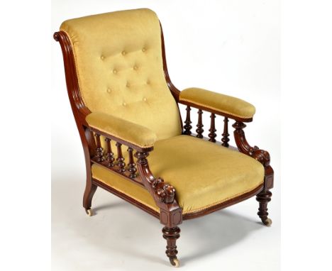 A Victorian mahogany easy chair, the buttoned back, arms and seat upholstered in green velour, the open arms raised on turned