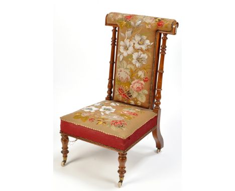 A Victorian rosewood prie dieu, upholstered in floral pattern tapestry and bead work, raised on turned legs terminating in ce