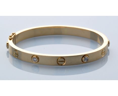 A diamond and yellow metal bangle, set with six brilliant cut diamonds weighing a total of approximately 0.60 carats, all col
