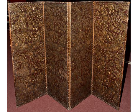 An early 19th Century gilt and embossed leather four-fold dressing screen, decorated with floral scrolls, birds, putti, monke