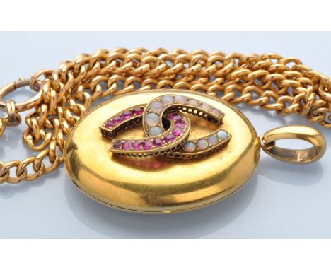 A Victorian yellow metal locket, the oval plain locket set with two entwined horseshoes, one set opal cabochons the other fac