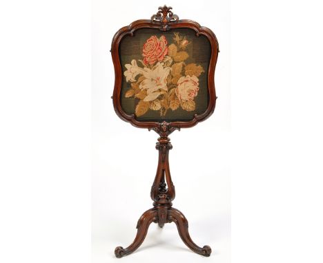 A Victorian carved walnut firescreen, the shaped screen with leaf cresting and acanthus border centred by a floral tapestry, 
