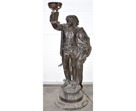 A late 19th Century spelter figural lamp, the male figure in 17th Century dress, raising a torch (converted to electricity), 