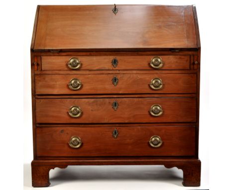 A George III walnut bureau, the fall-flap opening to reveal a fitted interior of central panel door, pigeon holes and drawers