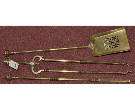 An early 20th Century brass set of three fireside implements, to include: shovel, tongs and a poker, each with circular shape