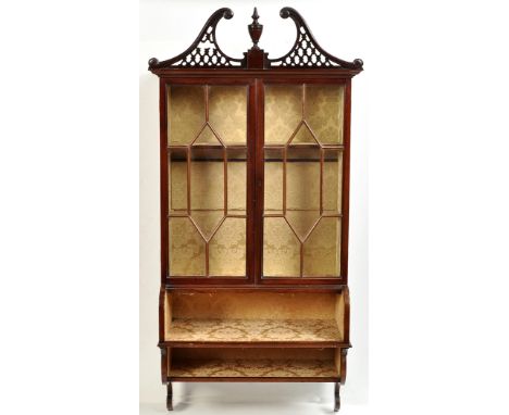 An Edwardian mahogany wall hanging china cabinet, the pierced scrolling cornice centred by urn finial, a pair of glazed astra