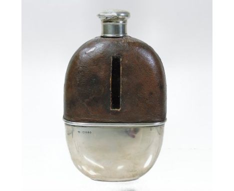 A Victorian leather clad glass hip flask, of oval shape, with a removable silver base and screw cover, London 1880, 15cm tall