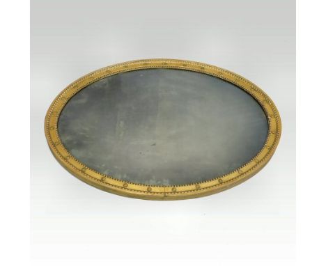 A Regency carved pine and gilt gesso framed oval wall mirror, the moulded surround with applied flower head decoration, 111 x