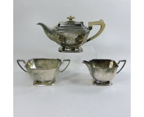 An early 20th century silver three piece tea service, of canted rectangular shape, on a pedestal base, comprising a teapot, 2