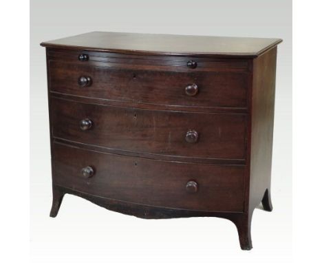 A George III mahogany bow front dressing chest, fitted with a brushing slide, over three long graduated drawers, on swept bra