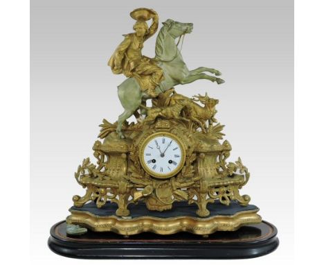 A 19th century gilt spelter figural mantel clock, the scrolled case surmounted by a Cavalier on horseback hunting a stag, wit