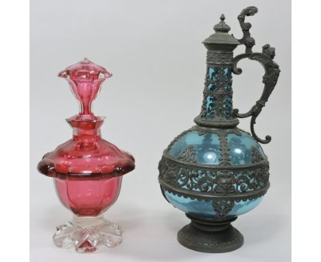 An ornate 19th century German pewter mounted blue glass ewer, with a scrolled figural handle, and strap work decoration, 33cm