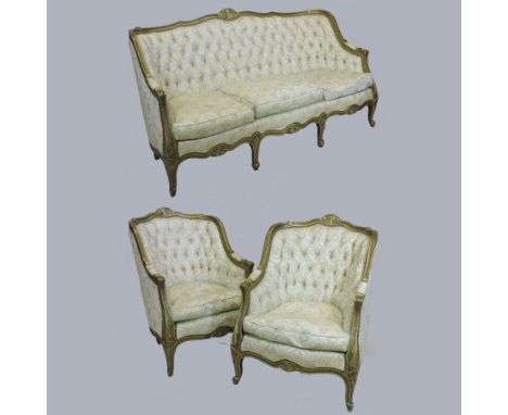 An early 20th century French style cream upholstered three piece suite, having a gilt show frame and button back, on cabriole