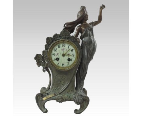 An Art Nouveau French spelter cased figural mantle clock, surmounted by a young lady having a painted enamel dial, striking o