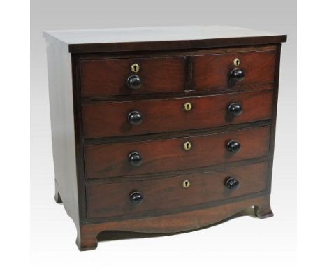 An early 19th century mahogany bow front apprentice chest, containing two short over three long locking drawers, with a shape