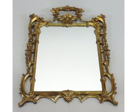 An early 20th century Rococo style gilt framed wall mirror, the rectangular plate within a scrolled and foliate openwork surr
