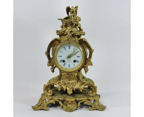 A 19th century French ormolu cased mantel clock, the ornate scrolled case surmounted by a pair of doves, the white enamel dia