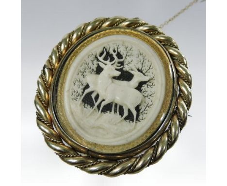 A 19th century unmarked reversible brooch, of oval shape, carved ivory with two stags to one side and an inset with a photogr