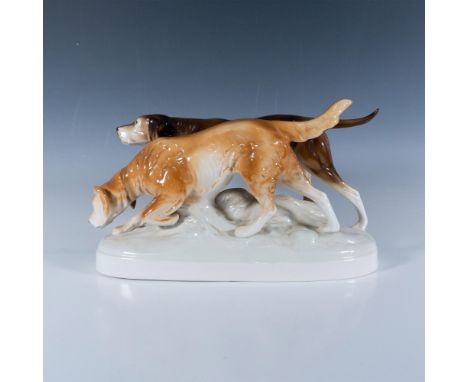 Small porcelain statue of two hunting dogs with the Royal Dux backstamp on the bottom. Dimensions: 14.5"L x 5.5"W x 8.25"HMan