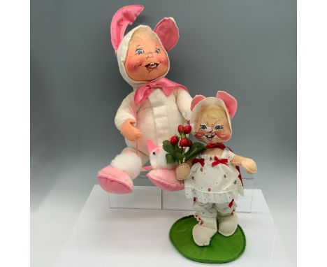 Darling set of holiday figures that includes a child wearing a bunny costume and bunny slippers, and a bunny modeling a straw