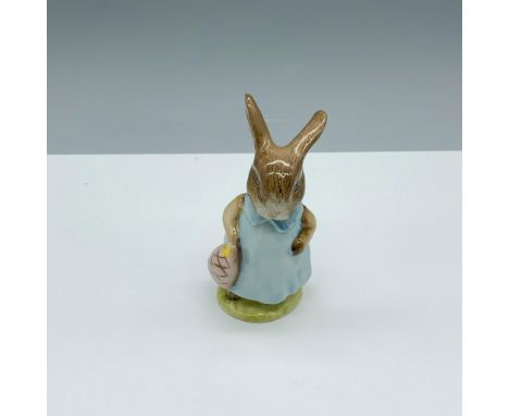 Glossy porcelain figure of a rabbit in a blue dress holding a bag. Royal Albert Beatrix Potter backstamp. This item has its o
