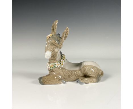 Glossy porcelain figure of a small donkey adorned with flower hair pin and a necklace. Lladro backstamp. This item has its or