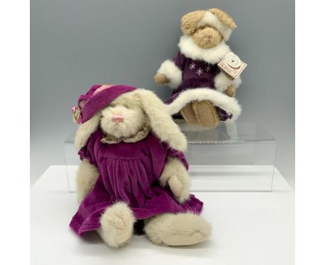 Adorable duo of rabbits that consists of a bunny in a purple dress with a matching hat, and a rabbit with her winter gown tha