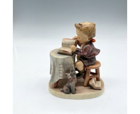 Adorable figure reading with his dog looking on. Goebel Hummel backstamp. 306. Issued: 20th centuryDimensions: 4"L x 2.5"W x 