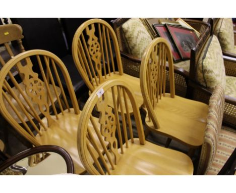 A set of four beech stick and wheel  back kitchen chairs