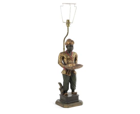 A BLACKAMOOR TABLE LAMP20TH CENTURYthe male figure standing before a brass lamp, wearing a turban and holding out a scallop s