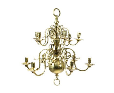 A DUTCH BRASS TWO-TIER TWELVE LIGHT CHANDELIERIN 18TH CENTURY STYLEwith a turned stem terminating in a large ball finial, the