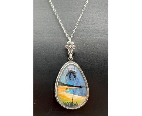 A vintage Thomas L Mott silver teardrop shaped butterfly wing pendant with floral design hanging bale. On a 16" silver chain 