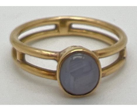 A bespoke made Macintosh style double band yellow metal dress ring with a bezel set oval grey agate cabochon. No marks but te