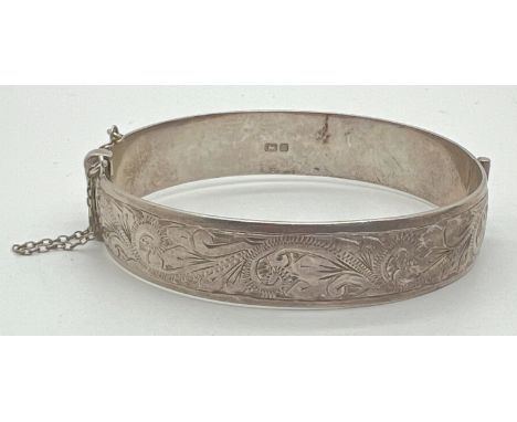 A vintage silver bangle with half floral decoration, push clasp, safety chain and inscription to inside "Mandy Love Duncan 29