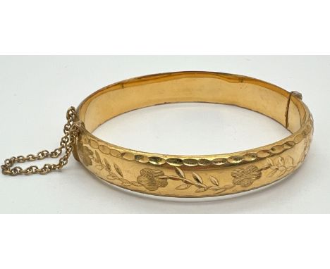 A vintage 9ct rolled gold bangle with safety chain and half floral engraved decoration. Marks to inside of bangle, approx. 6c