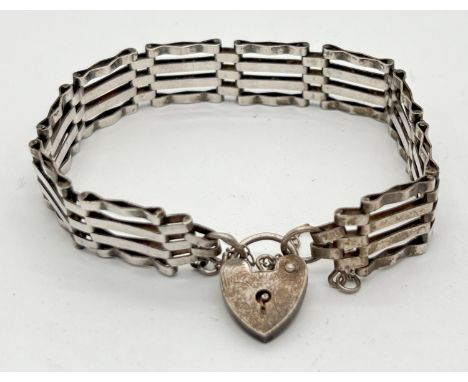 A vintage silver 4 bar gate bracelet with padlock and safety chain. Floral decoration to front of padlock and hallmarks for L