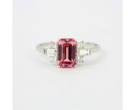 An 18ct white gold ring set with an emerald cut pink sapphire and brillinat and baguette cut diamond set shoulders, ring size