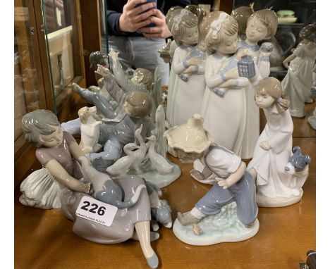 A group of nine Nao figurines, tallest 26cm.