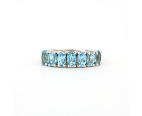 A 925 silver half eternity ring set with oval cut blue topaz, ring size N.5.