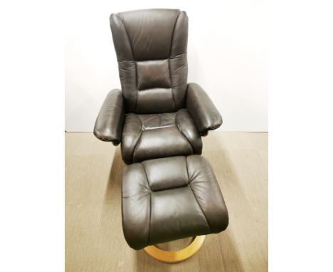 A revolving and reclining faux leather armchair and matching stool, H. 105cm.