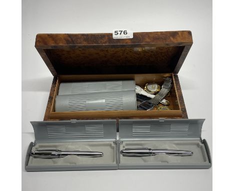 A bird's-eye maple cigar box with watch and pen contents.