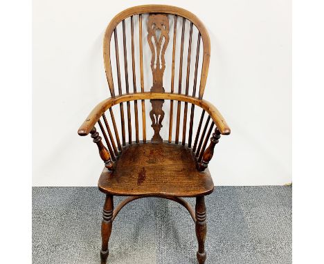 An early 19th-century English Elm and oak Windsor chair with crinoline stretcher, H. 105 cm.